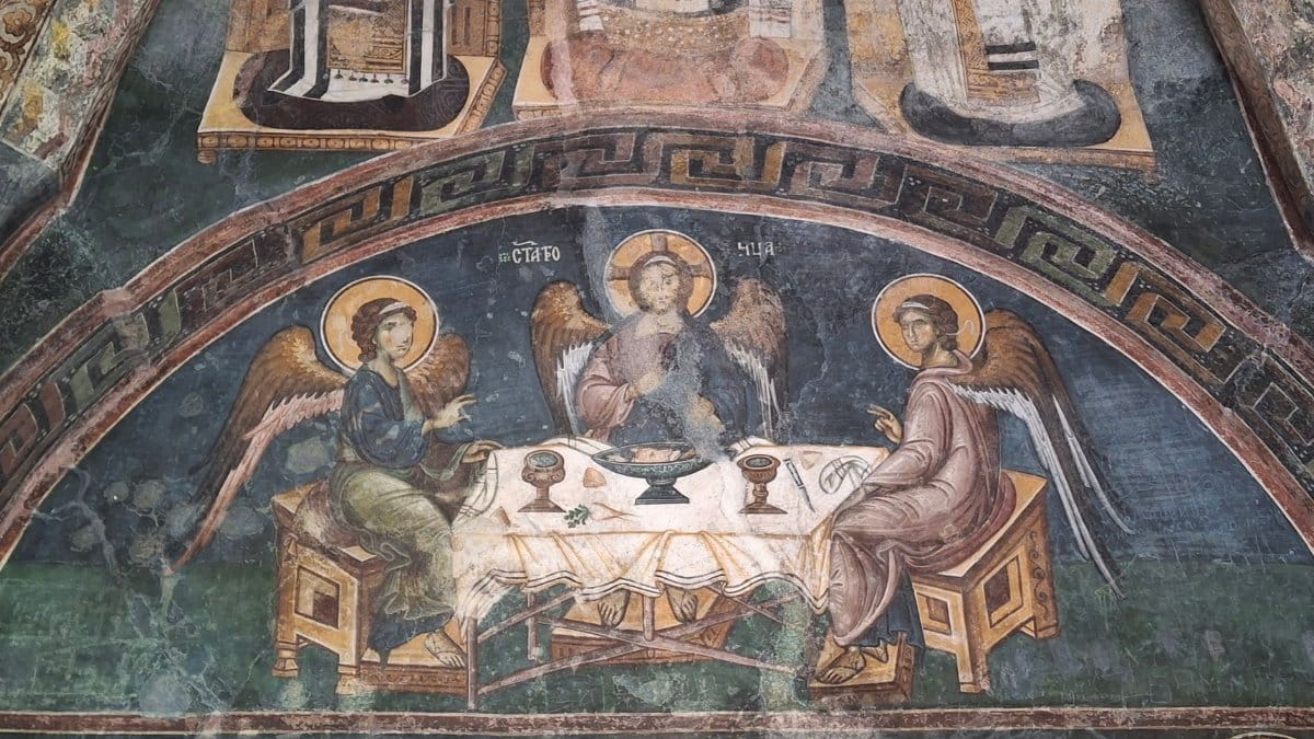 Detailed Byzantine fresco depicting angels in a classical dining setting.