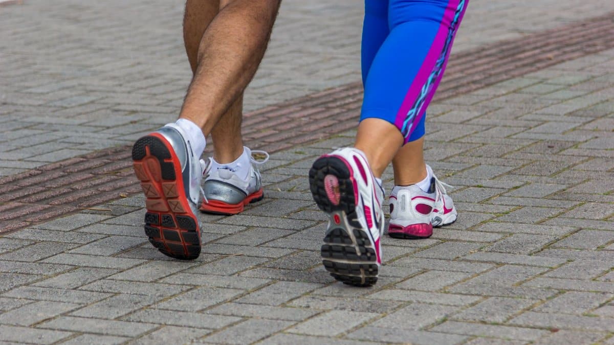 People jogging on a city street, giving a close-up of their sportswear shoes. Urban fitness scene.