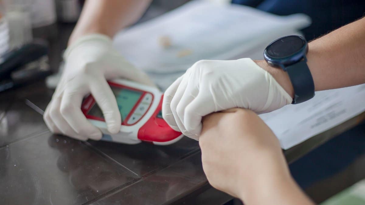 Close-up of a healthcare professional conducting a blood test with a glucometer, Ovejas, Colombia.