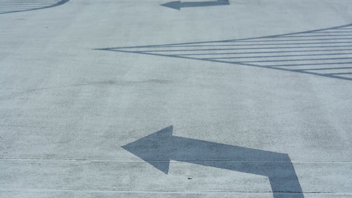 Concrete surface with abstract arrow patterns, conveying direction and movement.