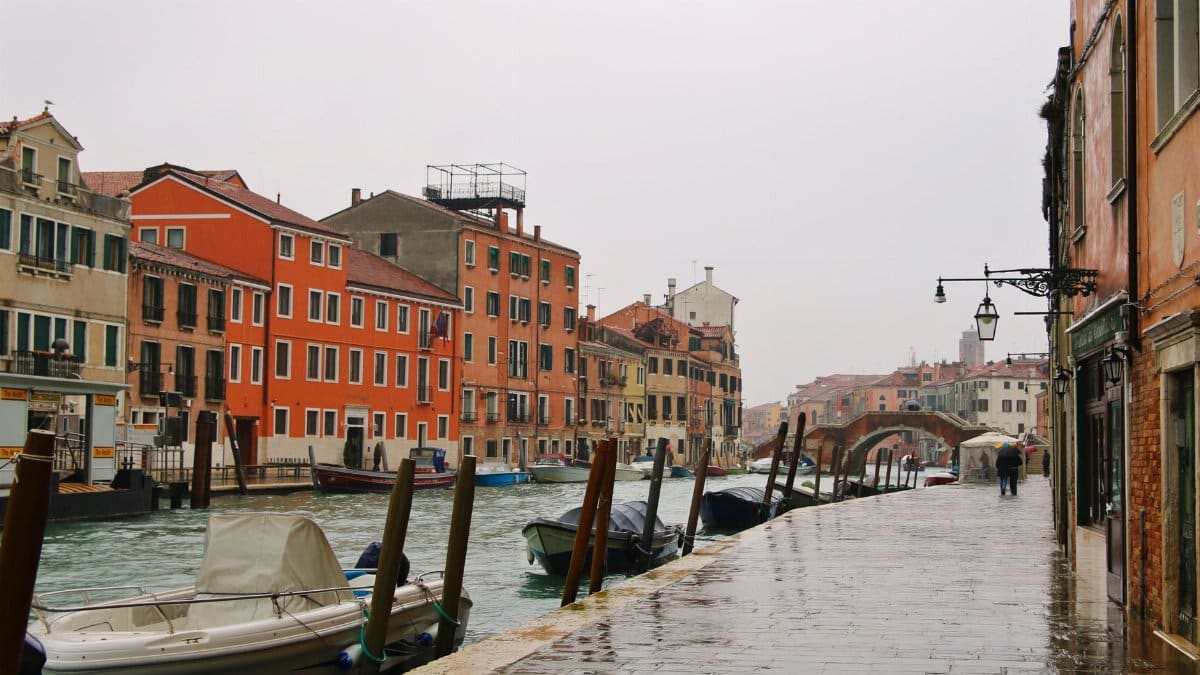 Explore the charming canals and architecture of Venice, Italy on a rainy day.