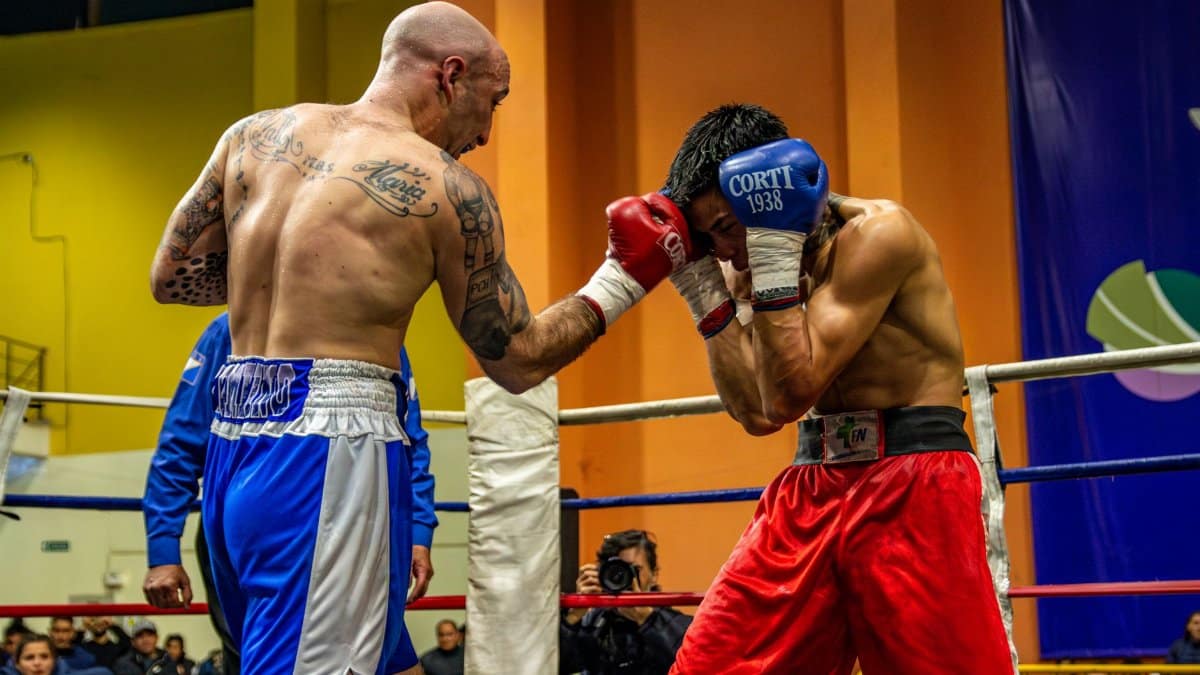 Intense boxing match between two male fighters showcasing strength and skill.