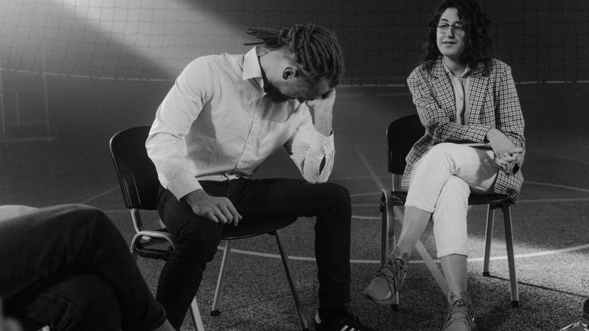 A therapy session with people discussing mental health in a supportive environment.