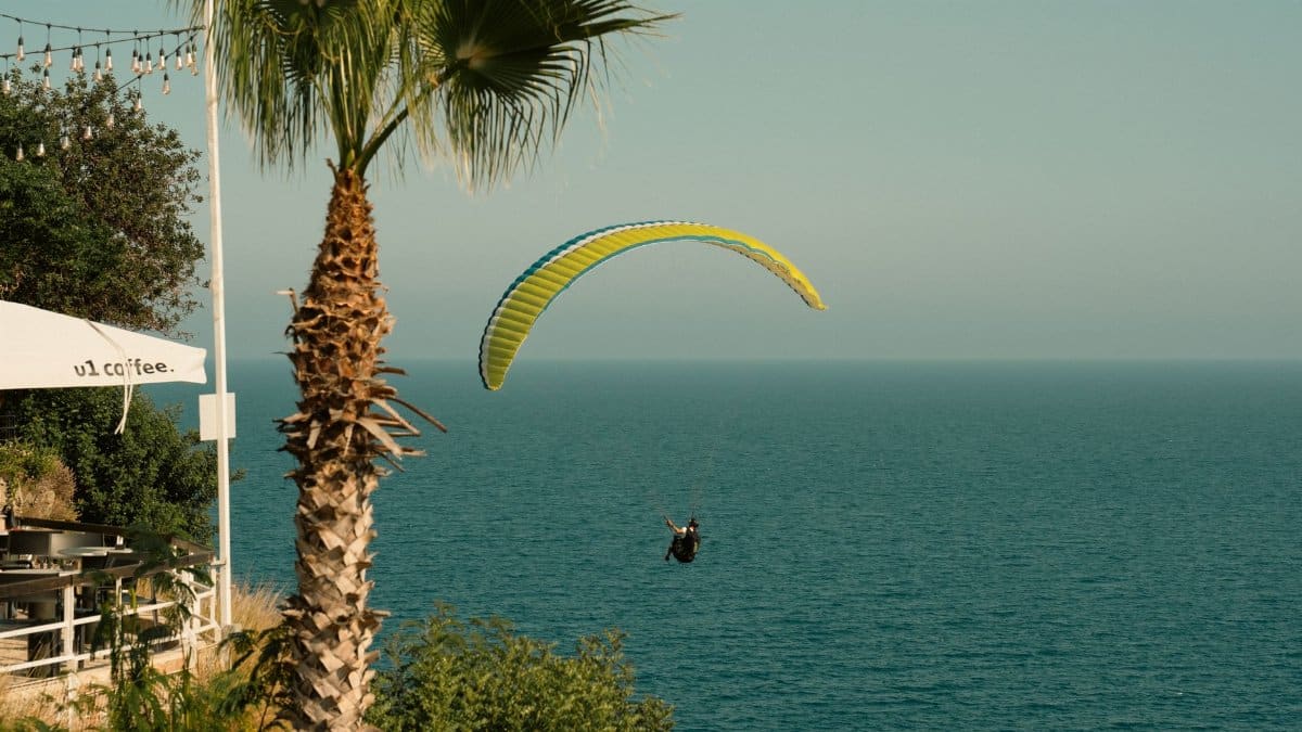 Thrilling paragliding flight over ocean cliffs, serene nature view.