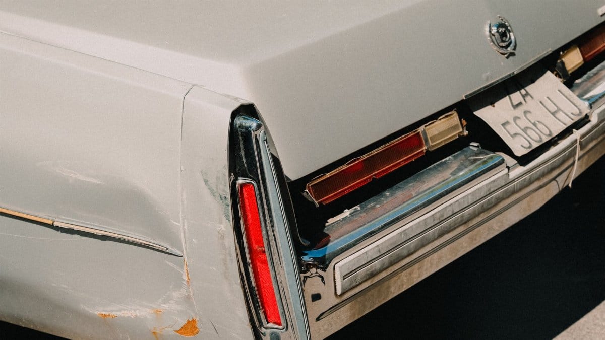 Rear view of a classic vintage car showcasing its tail light and retro license plate.