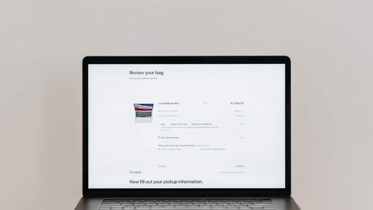 Minimalist laptop showing an online checkout screen on a white background, ideal for tech context.