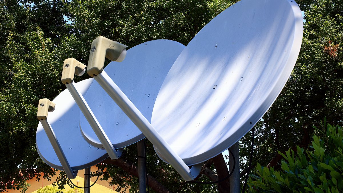 Satellite dishes in nature setting, emphasizing technology blend with environment.