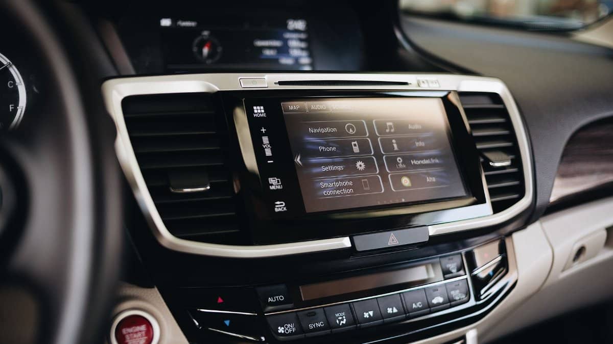 Close-up view of a modern car's infotainment display showing navigation and smartphone settings.