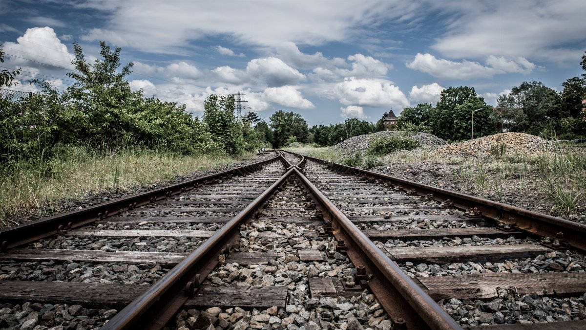 Rustic railway tracks under a cloudy sky in rural Geesthacht, perfect for travel and transport themes.