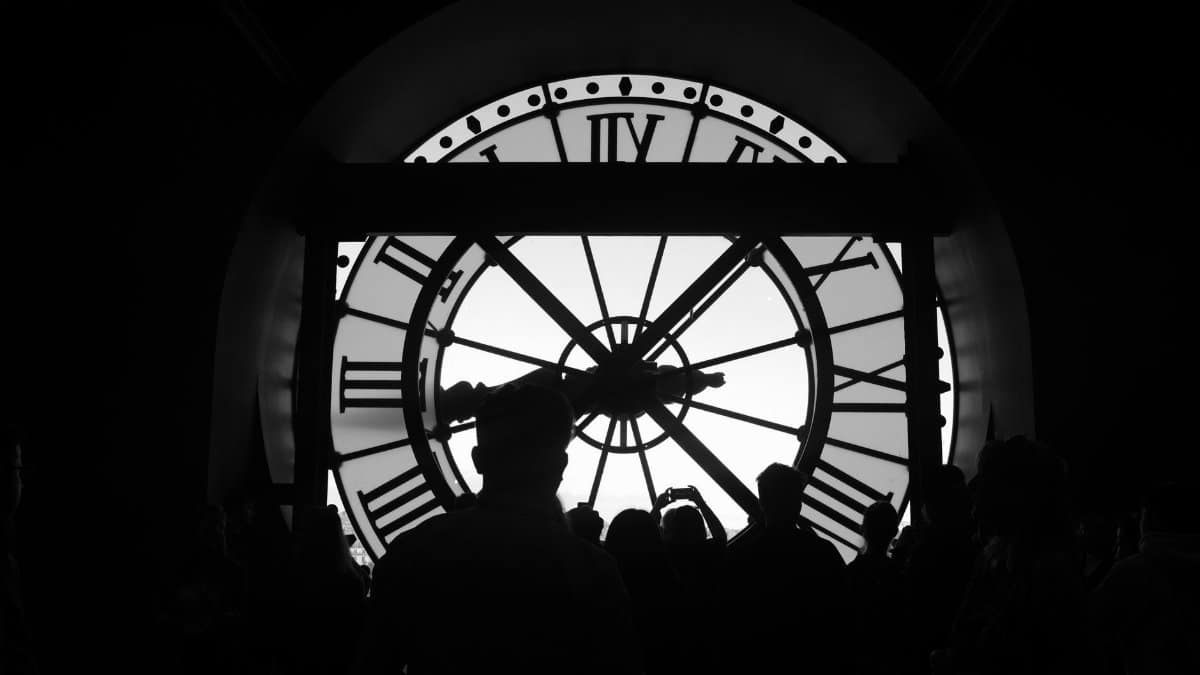 Silhouetted group in front of iconic Musée d'Orsay clock in Paris.