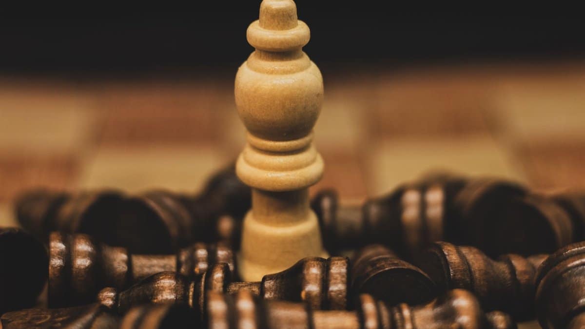 Intriguing close-up of a chess piece surrounded by scattered opponents, highlighting strategy and competition.