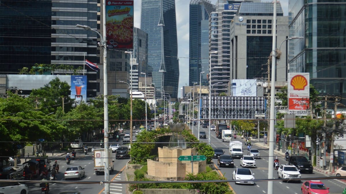 A vibrant view of Bangkok's bustling business district with modern skyscrapers and heavy traffic.