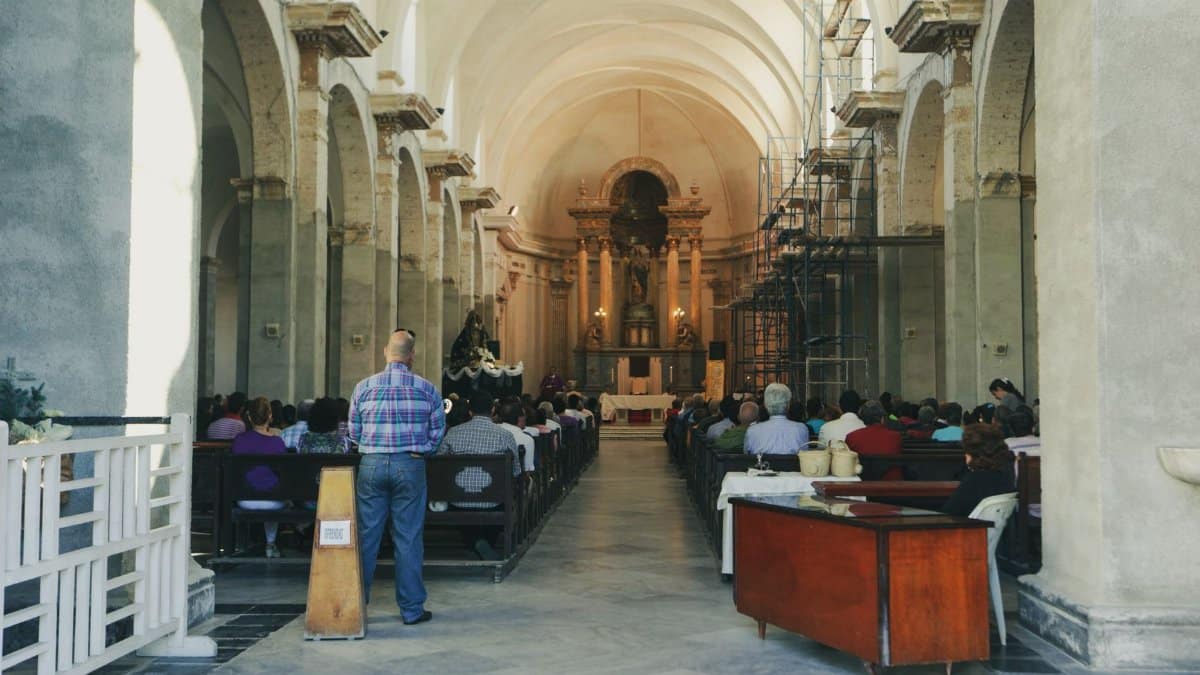 A serene church interior filled with people attending a service, highlighting architectural beauty and spirituality.
