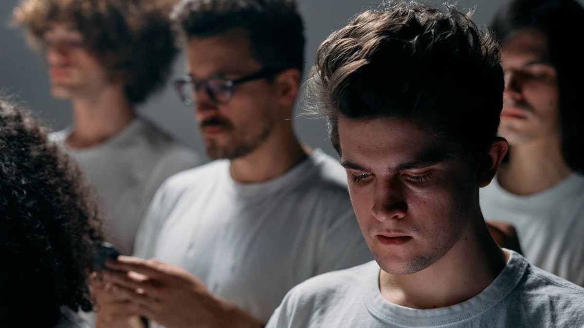 Individuals focused on smartphones, depicting modern social isolation and technology use.