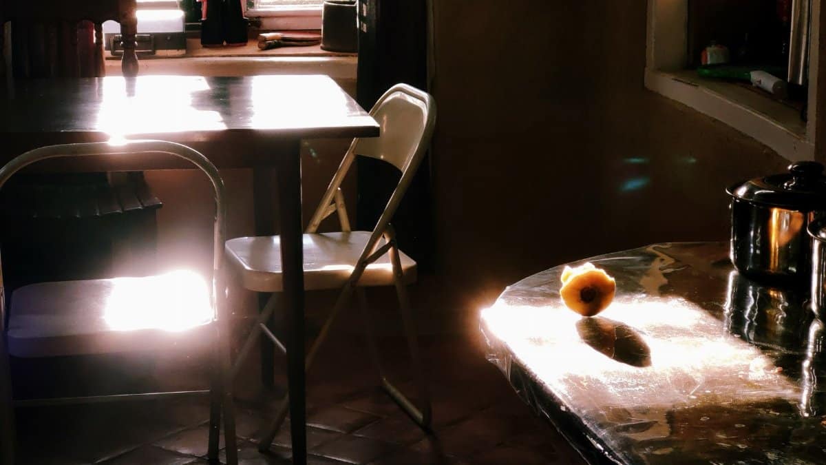 A cozy kitchen in Patlekhet, Nepal bathed in warm morning light with a single guava on the table.