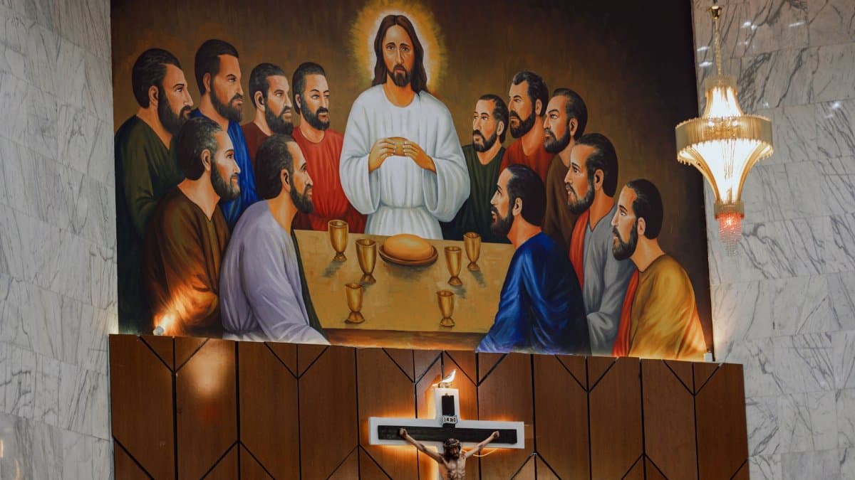 Vibrant mural of The Last Supper displayed in a church with chandelier and crucifix.