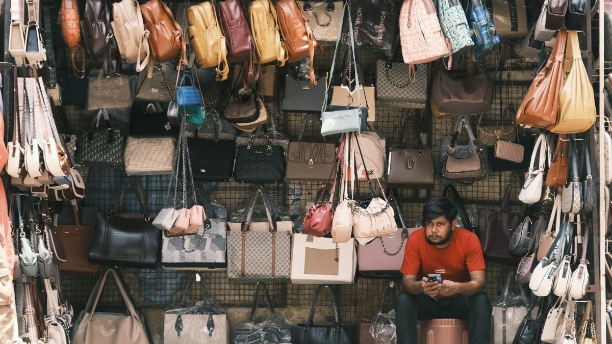 A local vendor selling a variety of bags in a bustling Bengaluru street market.