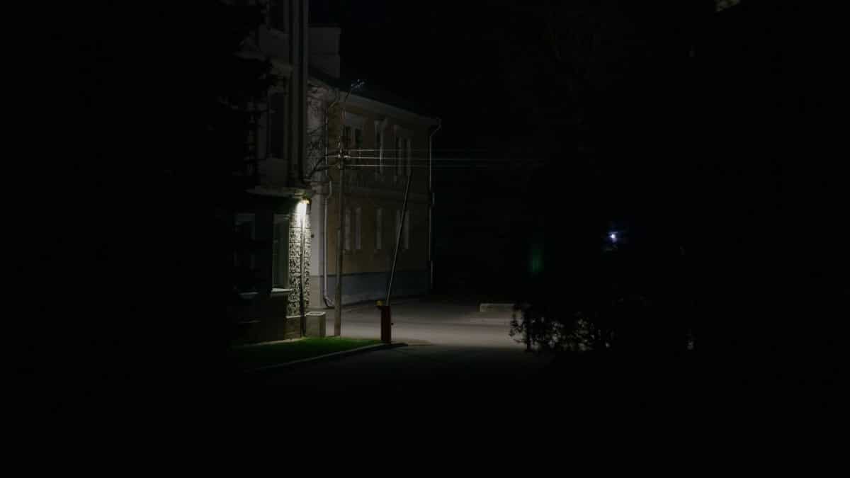 A dark and mysterious urban street view captured at night with subtle lighting.