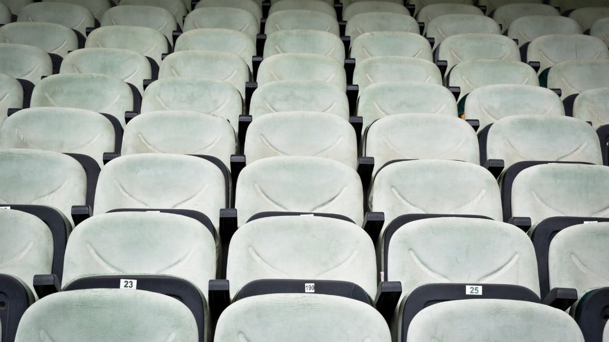 Rows of empty white seats in a cinema, perfect for concepts like solitude or seminar setups.
