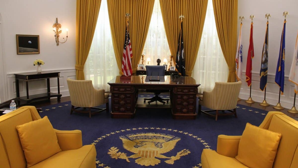 Interior of a presidential office showcasing elegant design with flags and majestic furnishings.