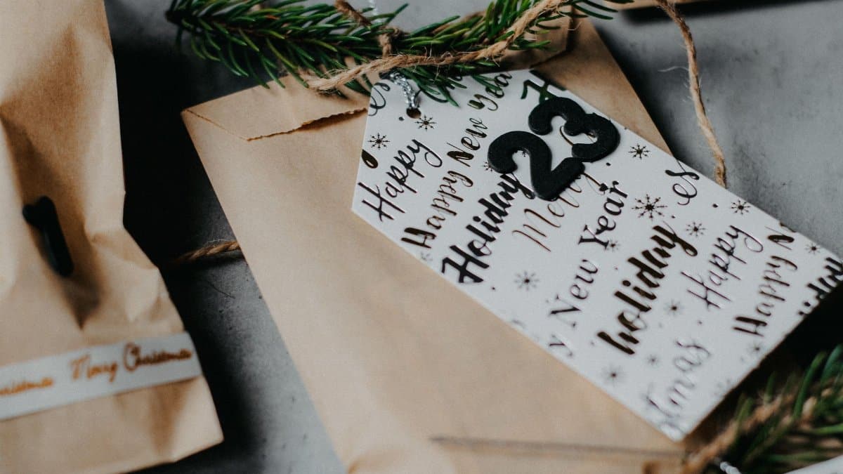 Close-up of a wrapped gift with an advent calendar tag and festive decorations.