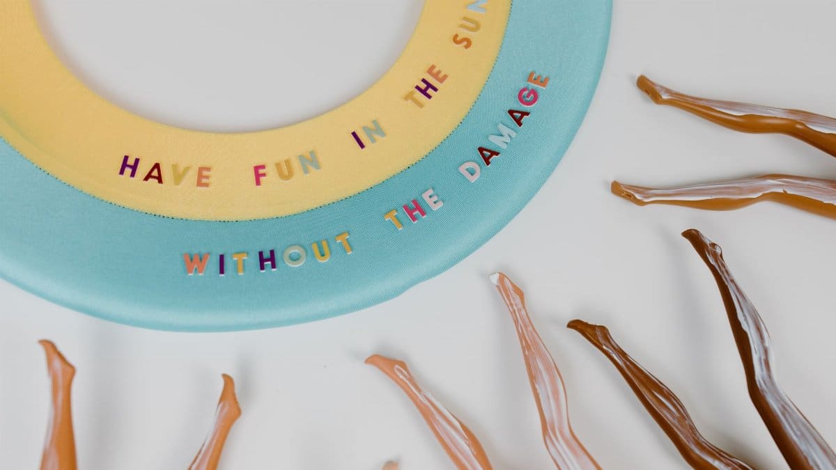 Artistic sunscreen concept promoting sun safety with vibrant lettering and textural contrast.