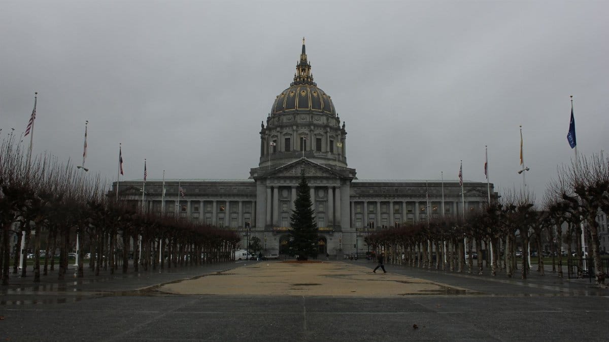 A view of San Francisco City Hall's majestic architecture set against a cloudy sky.