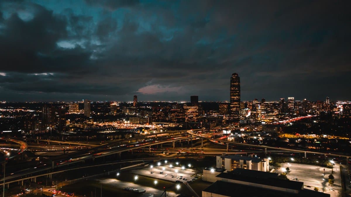 A breathtaking aerial shot of Houston's vibrant cityscape at night, featuring busy freeways and illuminated buildings.