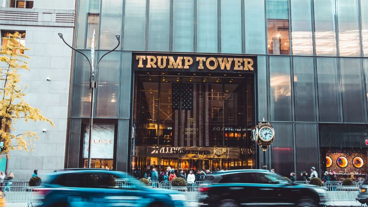 Dynamic view of Trump Tower's entrance with bustling street traffic in New York City.