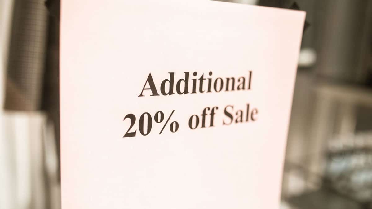 Close-up of a sale sign offering an additional 20% discount in a store window.