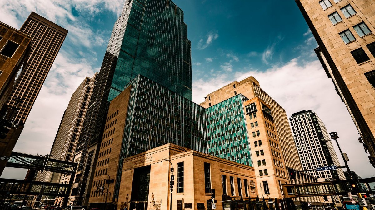 A dramatic view of modern skyscrapers in downtown Minneapolis under a vivid blue sky.