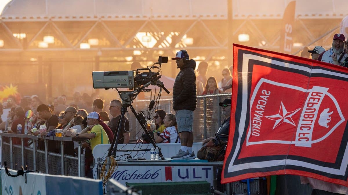 Vibrant scene of spectators enjoying an outdoor sports event at sunset.
