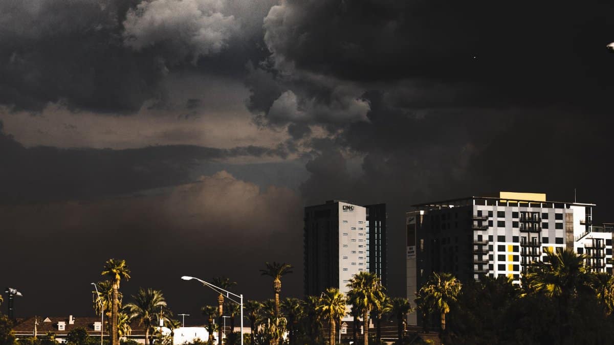 A city skyline under dark, stormy clouds creating a moody atmosphere.