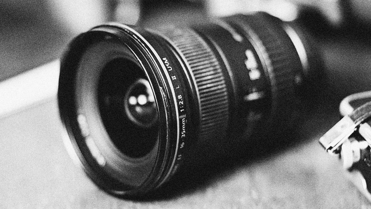 A monochrome close-up of a wide-angle camera lens with vintage appeal.