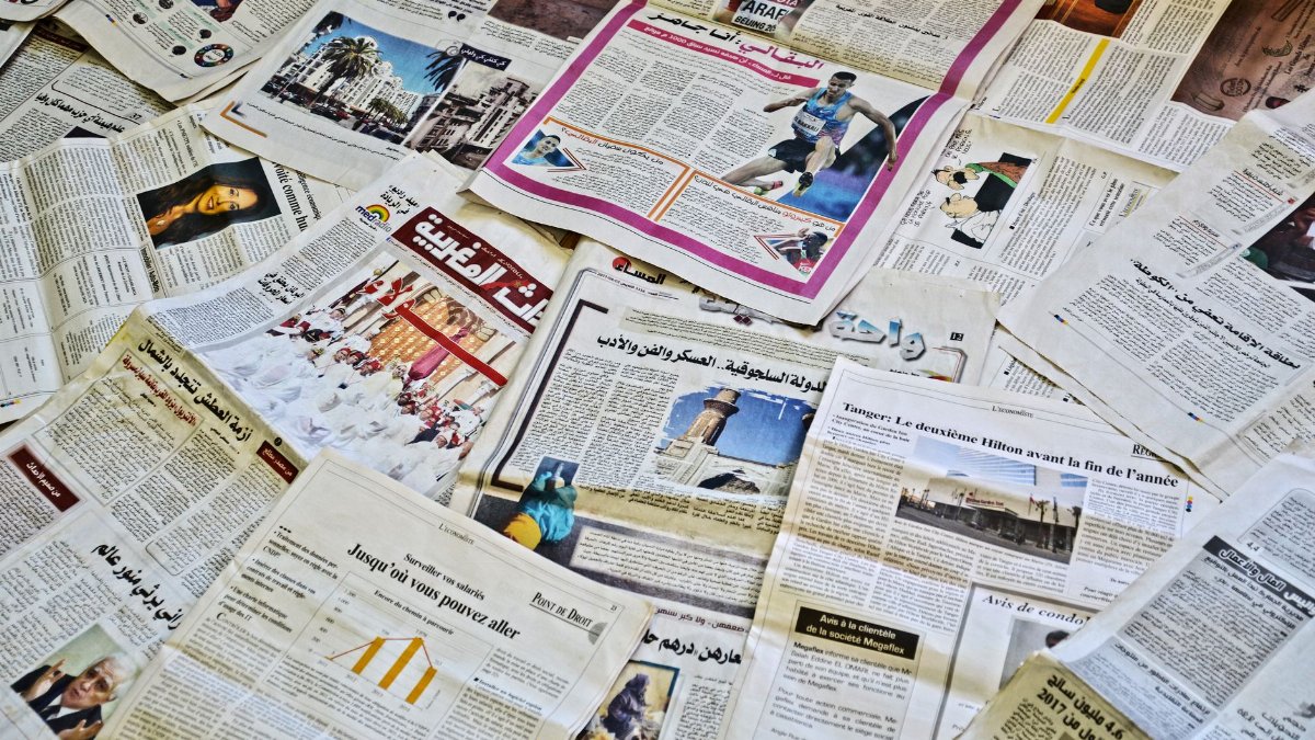 Close-up view of various newspapers laid out, showcasing diverse headlines and articles.