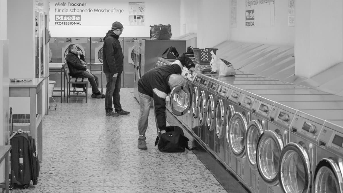 Laundromat interior with people using washing machines, Berlin.