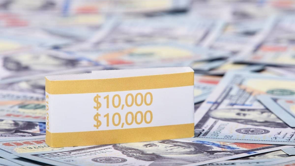 Close-up image of a stack of US dollars with a $10,000 band, symbolizing wealth and finance.