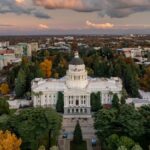 Aerial image of the California State Capitol surrounded by colorful fall foliage in Sacramento.
