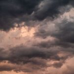 Dramatic overcast sky with dark storm clouds and soft sunset hues.