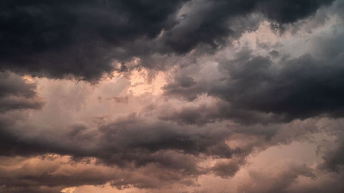 Dramatic overcast sky with dark storm clouds and soft sunset hues.
