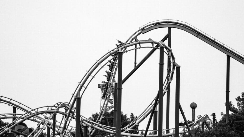 Dramatic black and white photo of a looping roller coaster, capturing thrills and excitement.
