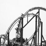 Dramatic black and white photo of a looping roller coaster, capturing thrills and excitement.