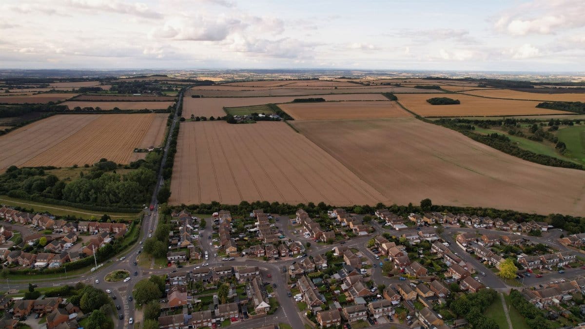 Aerial view capturing Luton, England's picturesque countryside and croplands at day.