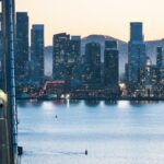 Dusk view of San Francisco skyline with the Bay Bridge and waterfront, showcasing urban architecture.