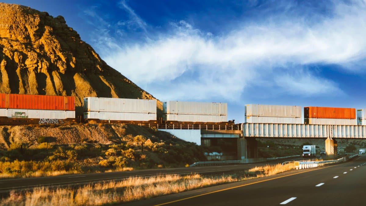 Freight train crossing through Nevada desert landscape with a clear blue sky, capturing the essence of transportation.