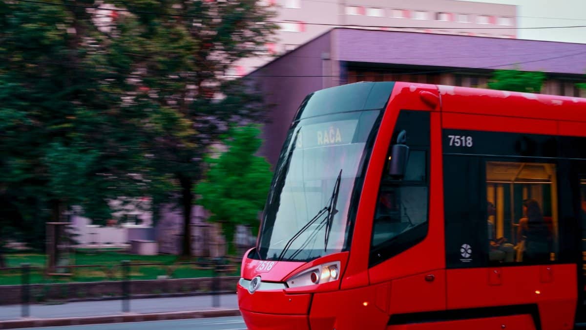 Dynamic shot of a red tram in motion on the streets of Bratislava, Slovakia.