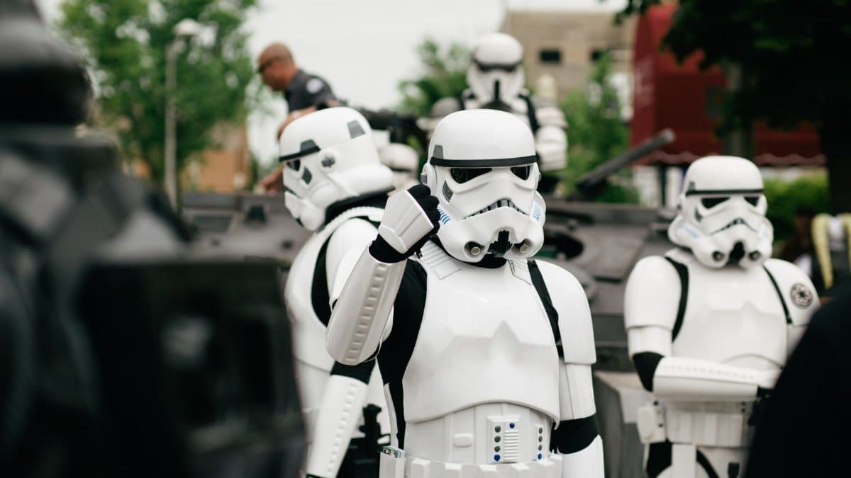 Group of Star Wars stormtrooper cosplayers gathering outdoors during the day.