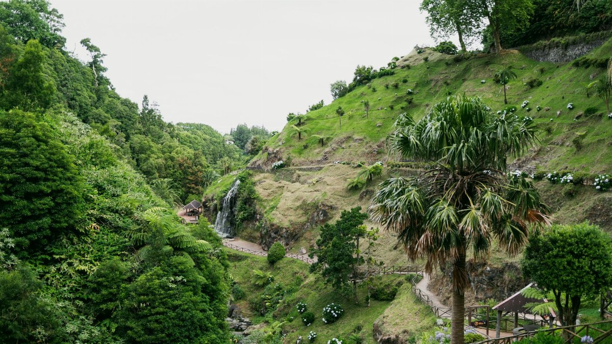 A picturesque landscape featuring a waterfall in the verdant hills of the Azores, Portugal.
