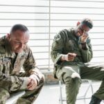 Veterans share a light moment during a group therapy session, indoors.