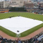 Aerial view of Comerica Park in Detroit with the baseball field covered, surrounded by the city skyline.